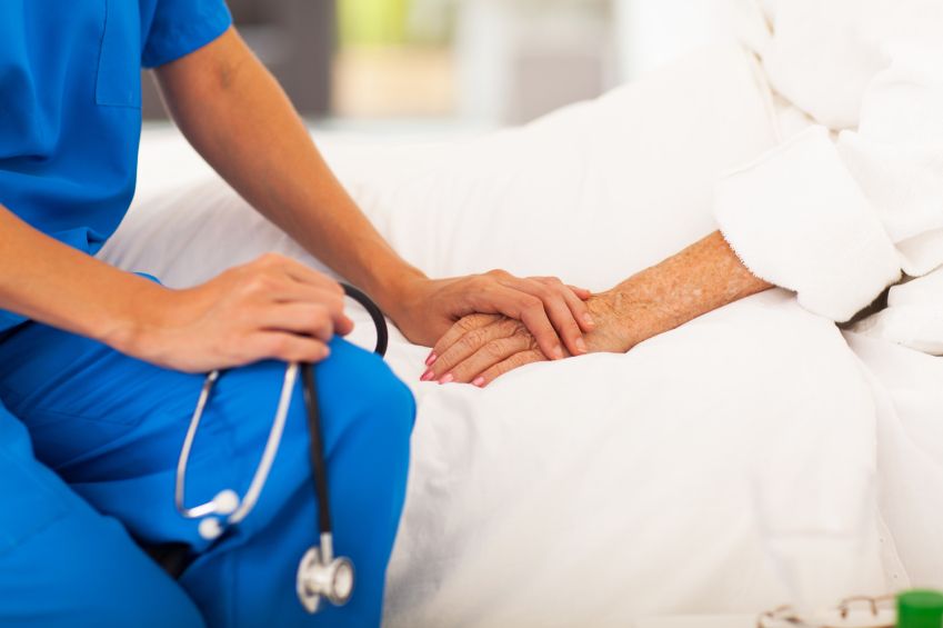 A doctor holding hands with an elderly person for the personal care for seniors program at MasterPeace Home Health Care in Mattapoisett, MA