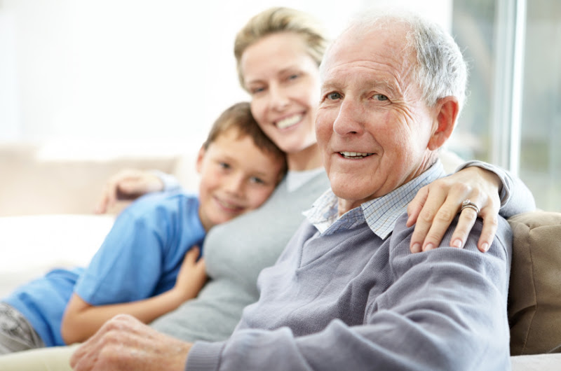 A elderly man sitting with his family